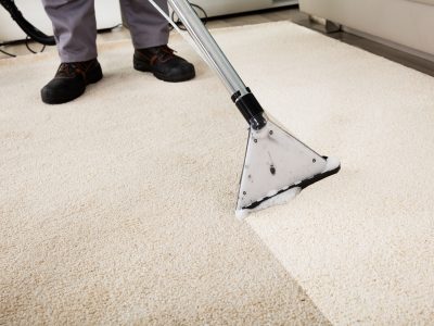 Close-up Of A Person Cleaning Carpet With Vacuum Cleaner